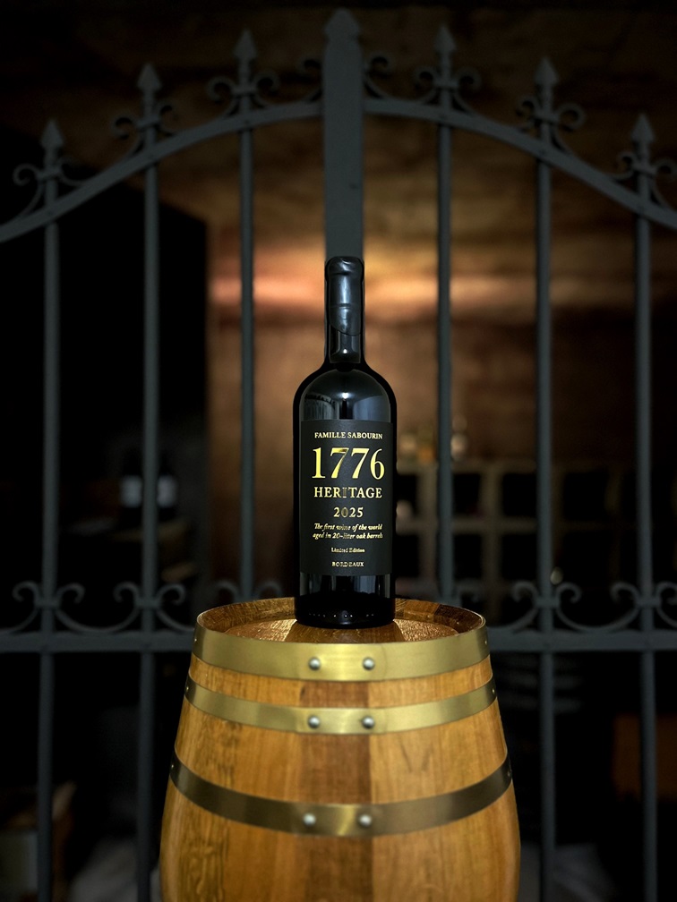 Bouteille du vin rouge 1776 HERITAGE posée sur une barrique dans la cave de la Famille Sabourin à Cars, France